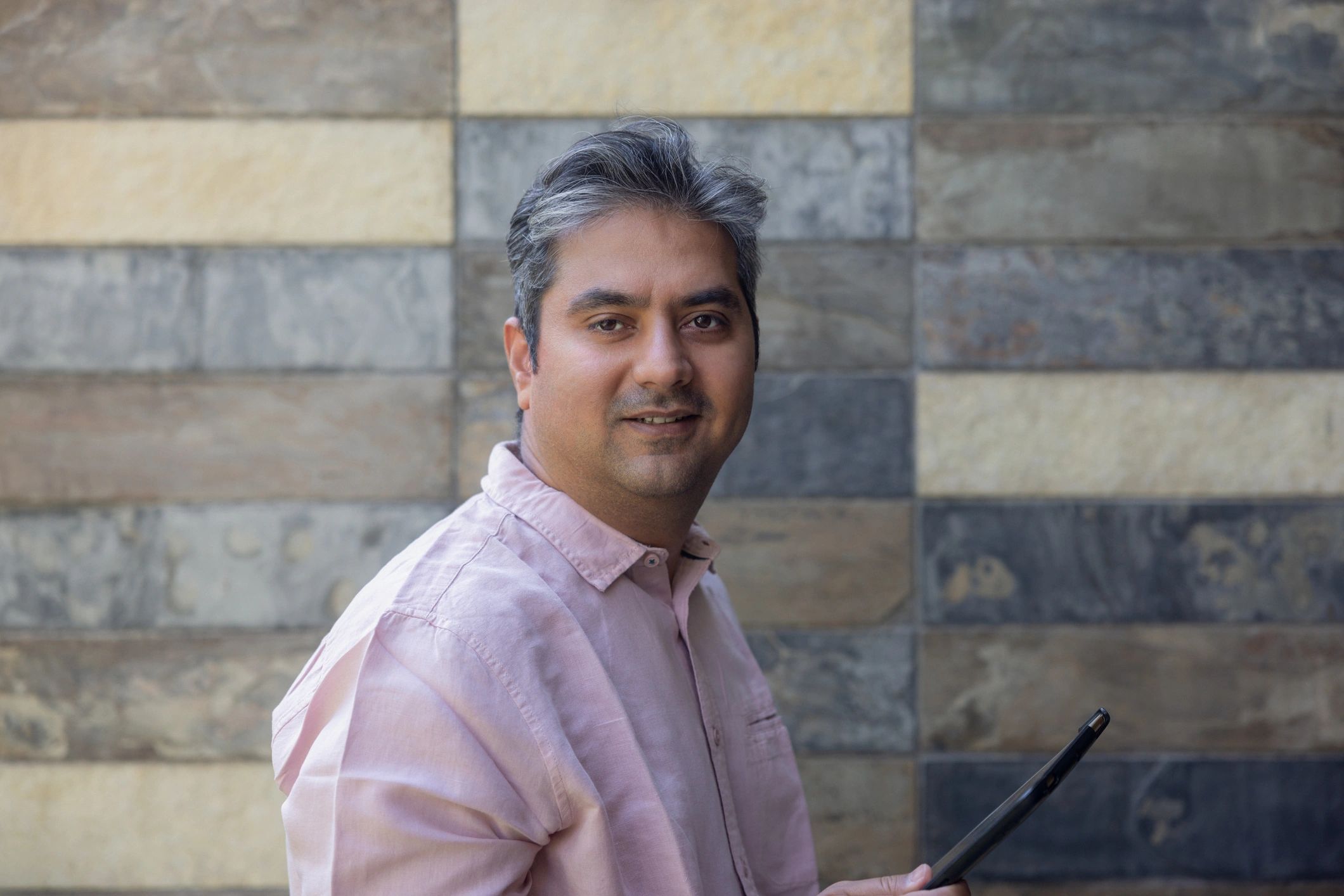 Indian-origin professional with a polished global profile in a refined business setting